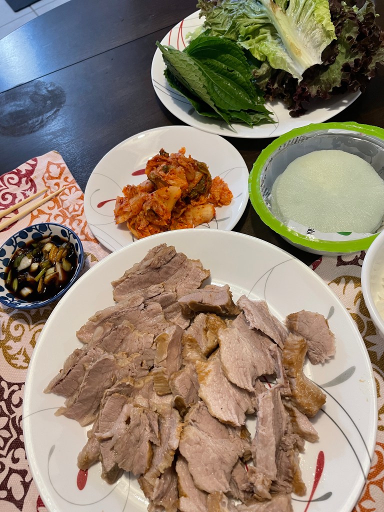 Pork belly with dipping sauce, veggies, kimchi, and wasabi radish slices